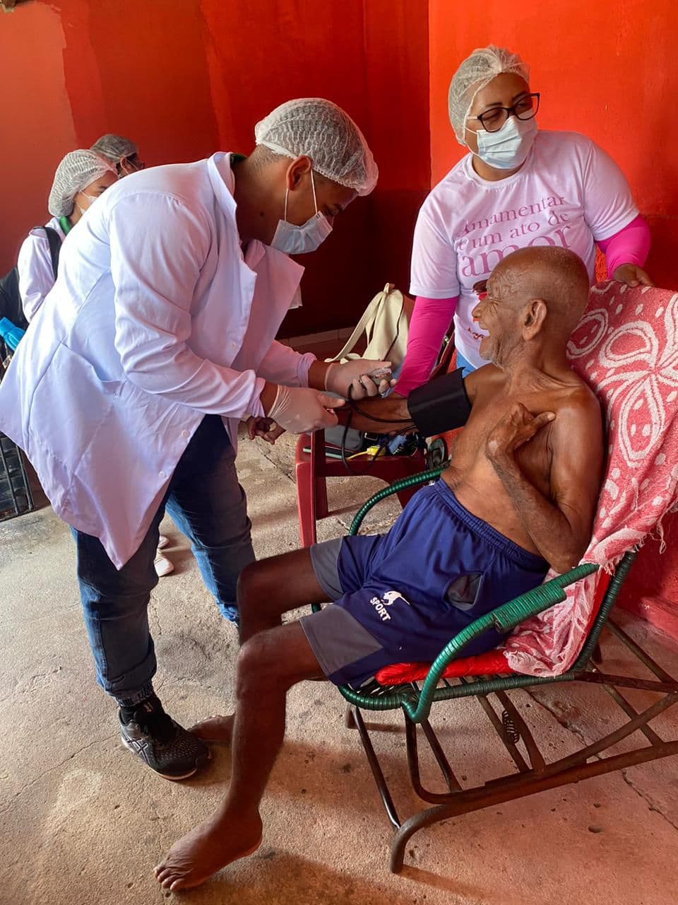 Enfermeiro Levi Jorda aferindo a pressão arterial de paciente em atendimento home care em Alagoas